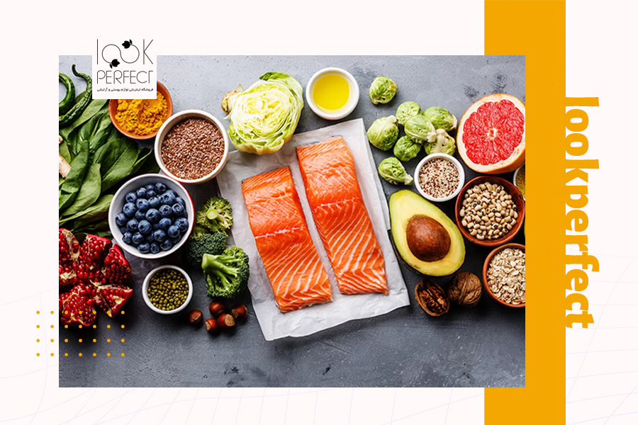 مجموعهای از مواد غذایی سالم از جمله ماهی سالمون، آووکادو، زغالاخته و سبزیجات – نقش تغذیه در کاهش آکنه