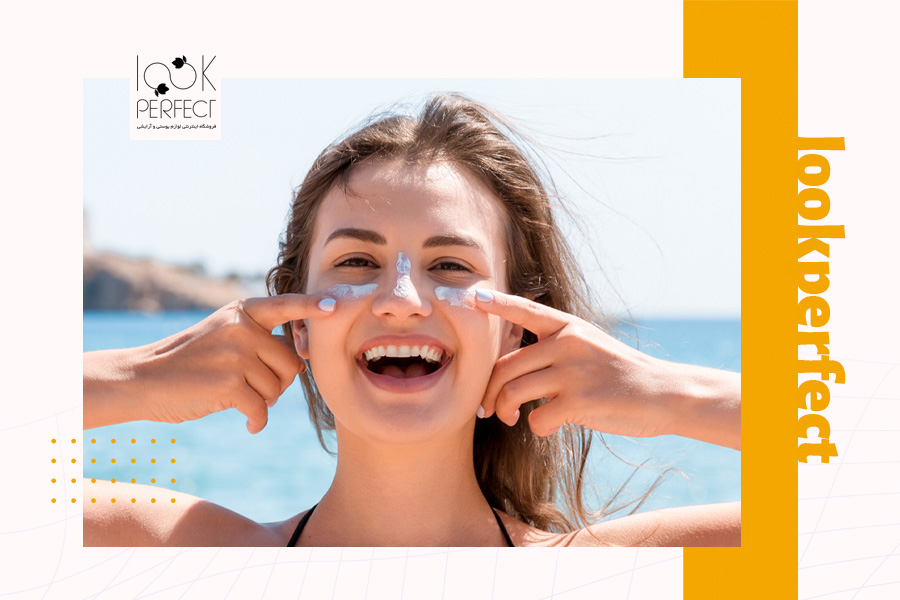 زنی در حال لبخند زدن در ساحل، در حالی که کرم ضد آفتاب روی گونهها و بینی خود زده است – اهمیت استفاده از ضد آفتاب برای پوست مستعد آکنه.